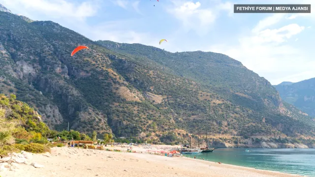 Ölüdeniz'de Belcekız sahili üzerinde uçuş yapan yamaç paraşütleri