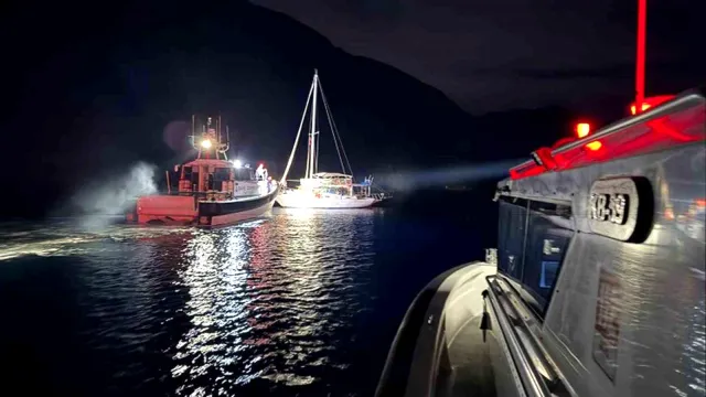 Sahil Güvenlik botu, Ortaca açıklarında durdurulan gezi teknesini ışıkla aydınlatırken