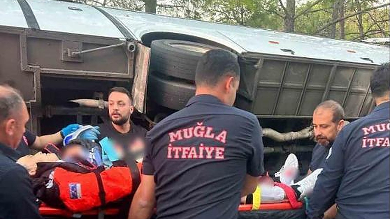Devrilen servis midibüsünün yanında yaralıyı taşıyan itfaiye ekibi