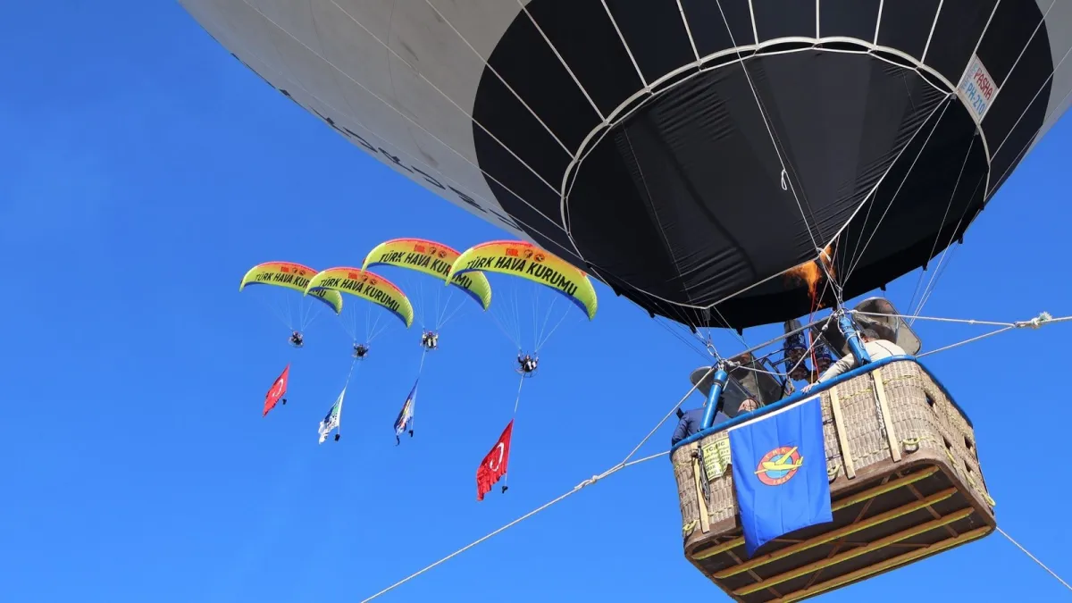 Paramotor pilotları Türk Hava Kurumu sıcak hava balonunun yanında uçuyor