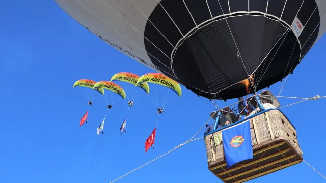 Paramotor pilotları Türk Hava Kurumu sıcak hava balonunun yanında uçuyor