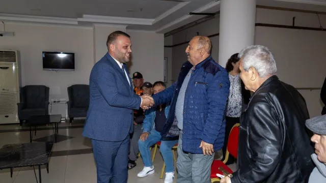 Muğla Romanlar Derneği Başkanı Hüseyin Can Demirtaş huzurevi sakinleriyle tokalaşıyor