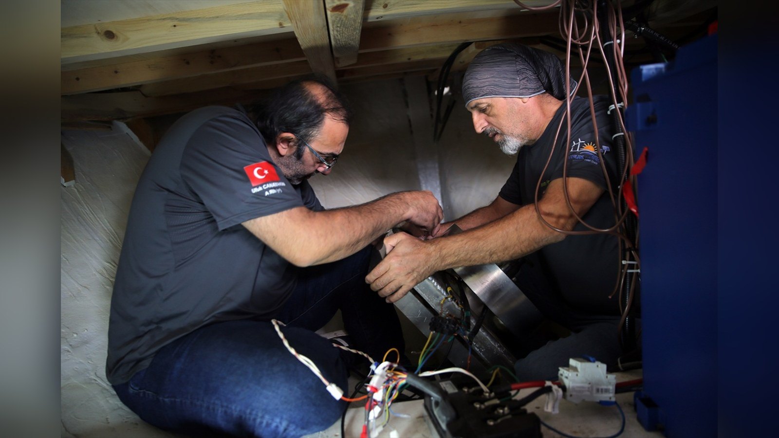 Elektrikli tur teknesinin motor sistemi üzerinde çalışan ustalar